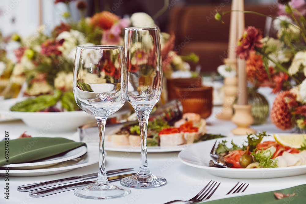 Aesthetics autumn table setting, arranged flowers and candles under stylish natural light. Cozy holidays table setup