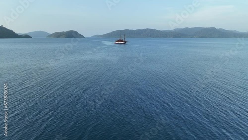 Calm seas surround a phinisi diving liveaboard in Alyui Bay on Waigeo Island in Raja Ampat. This scenic area is known as the heart of the Coral Triangle due to its incredible marine biodiversity. photo