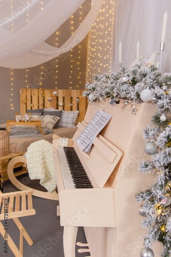 Christmas tree with white flowers and a white piano.