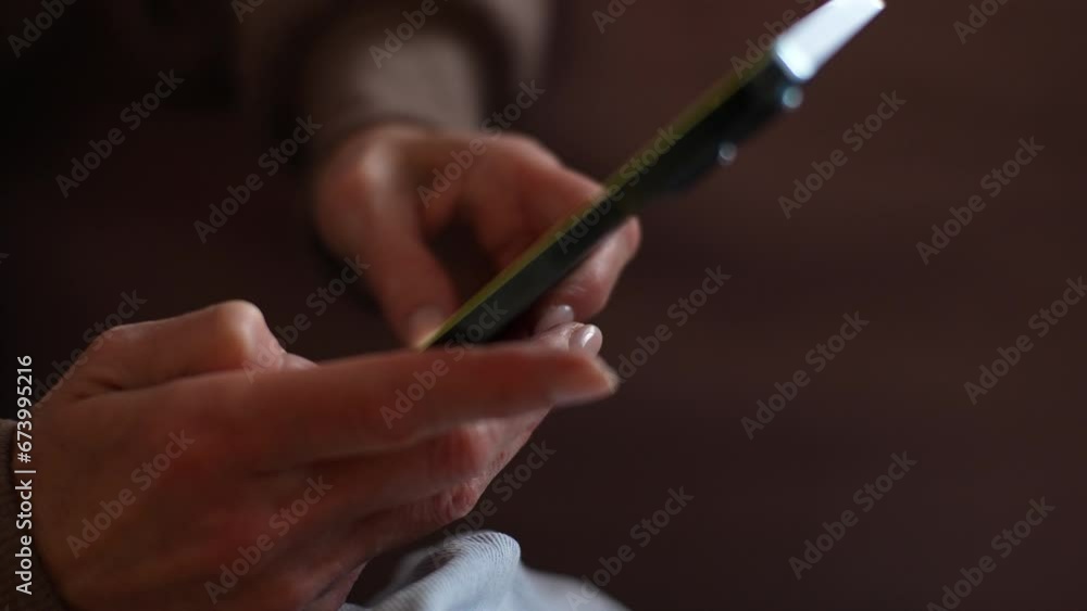 Close-up of unrecognizable middle-aged female hands holding smartphone scrolling news feed. Closeup of senior woman using social media network platform app, online chat, choose and buy goods, slowmo. Close-up of unrecognizable middle-aged female hands holding smartphone scrolling news feed. Closeup of senior woman using social media network platform app, online chat, choose and buy goods, slowmo.