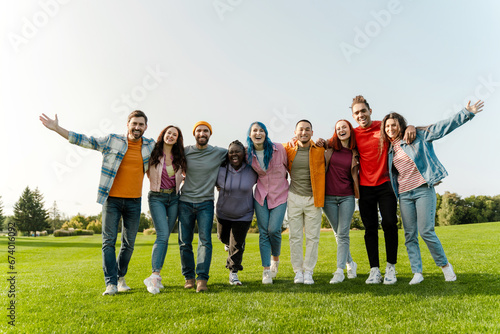 Group portrait of smiling multiracial smiling friends hugging wearing stylish colorful clothes