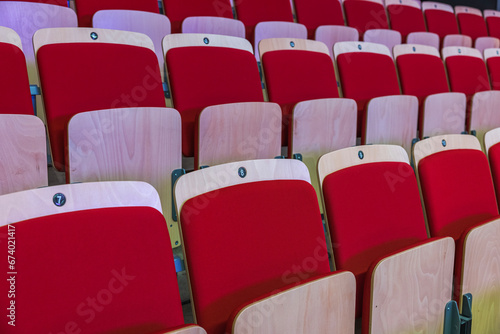View of stands with comfortable red chairs at sports complex. 