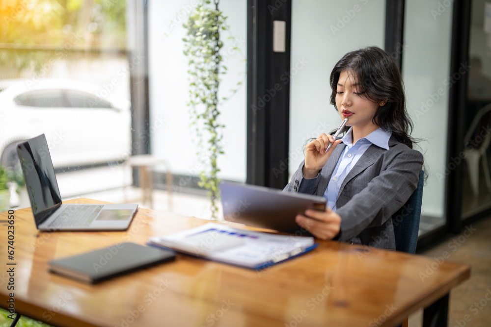 Business woman sitting and working using tablet to check news, information, marketing plan Business woman sitting and working using tablet to check news, information, marketing plan