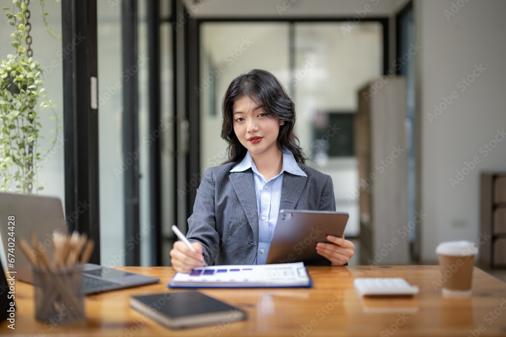 Business woman sitting and working using tablet to check news, information, marketing plan Business woman sitting and working using tablet to check news, information, marketing plan