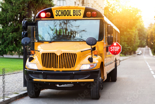 Old-fashioned yellow school bus with red stop sign on the side photo