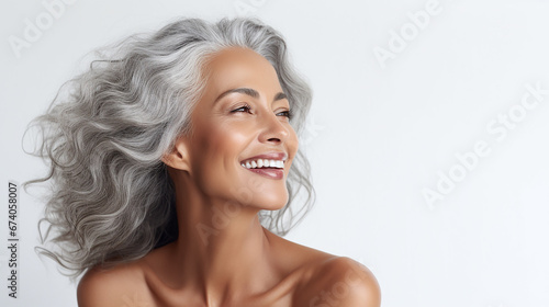 Black adult woman touch face with smooth healthy skin. Beautiful aging mature woman with long gray hair and happy shy smiling. Beauty and cosmetics skincare advertising concept, white background photo
