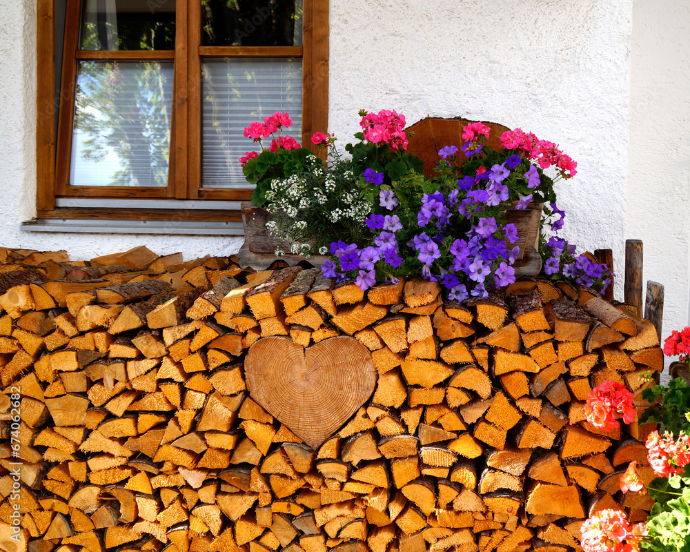 Φωτογραφία rustic alpine Bavarian farmhouse with a traditional pile of firewood and colorfu