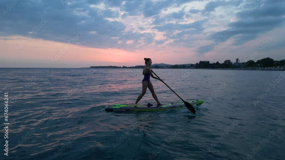 sexy girl on a sup board swims at sunset in a beautiful sea. High quality 4k footage sexy girl on a sup board swims at sunset in a beautiful sea. High quality 4k footage