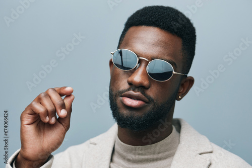 Cheerful african man wearing glasses jean jacket having white snow smile pointing fingers aside at copy space for your text advertisement, advertise teeth whitening or eyewear store good offer concept photo