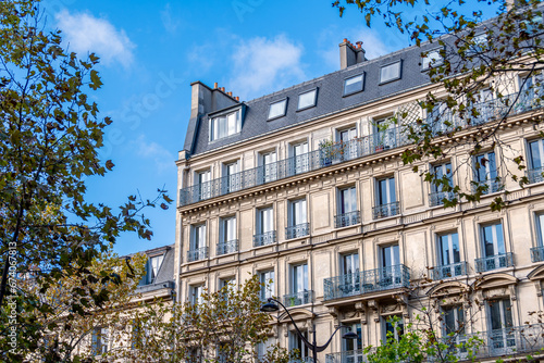 Façade d'un immeuble résidentiel de style classique à Paris situé dans une avenue bordée d'arbres. Concept de marché immobilier d'habitation pour les logements anciens en France © HJBC