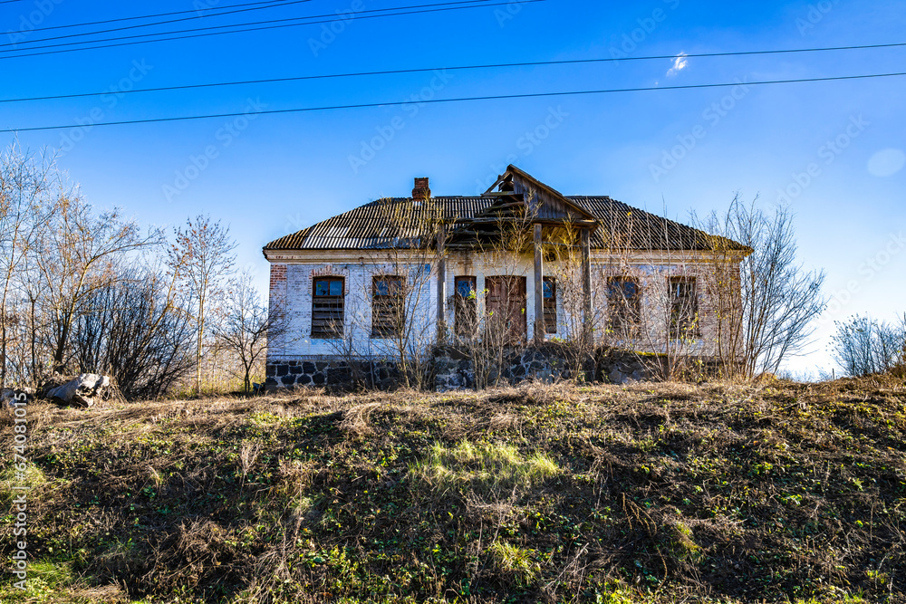 An old, abandoned brick house on a hill.