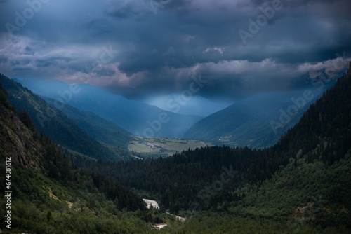 Distant view, valley among high Caucasian mountains, summer evening, dramatic rain clouds. way to Shdugra waterfall, Mazeri, Svaneti, Georgia © Sergey