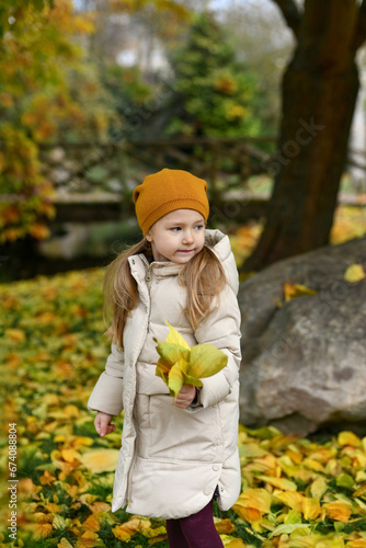 Girl holding leaves in the autumn park