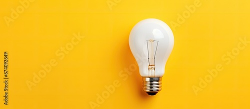 A light bulb of ivory color set apart on a sunny backdrop conveying a business idea An area is kept free for replicating content photo