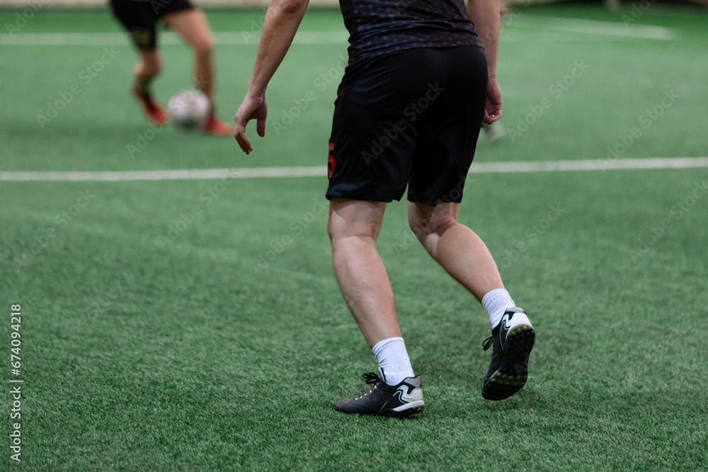 Mini soccer football players playing game in indoor stadium on artificial turf. Mini soccer football players playing game in indoor stadium on artificial turf.