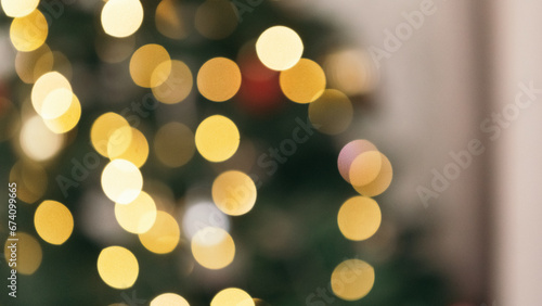 Blur bokeh defocused cozy flat apartment photo studio room green Christmas Tree gifts presents garlands, candles decorated toys balls interior New Year lights glowing 