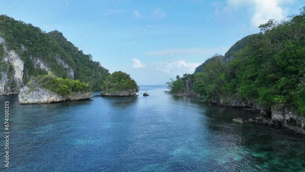 Shallow coral reefs fringe a narrow channel amid the calm waters of Alyui Bay, Raja Ampat. This scenic area is known as the heart of the Coral Triangle due to its incredible marine biodiversity. Shallow coral reefs fringe a narrow channel amid the calm waters of Alyui Bay, Raja Ampat. This scenic area is known as the heart of the Coral Triangle due to its incredible marine biodiversity.