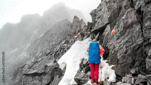 Ein Wanderin bei der Alpenüberquerung im Schnee und schlechter Witterung am Pitztaler Jöchl. photo