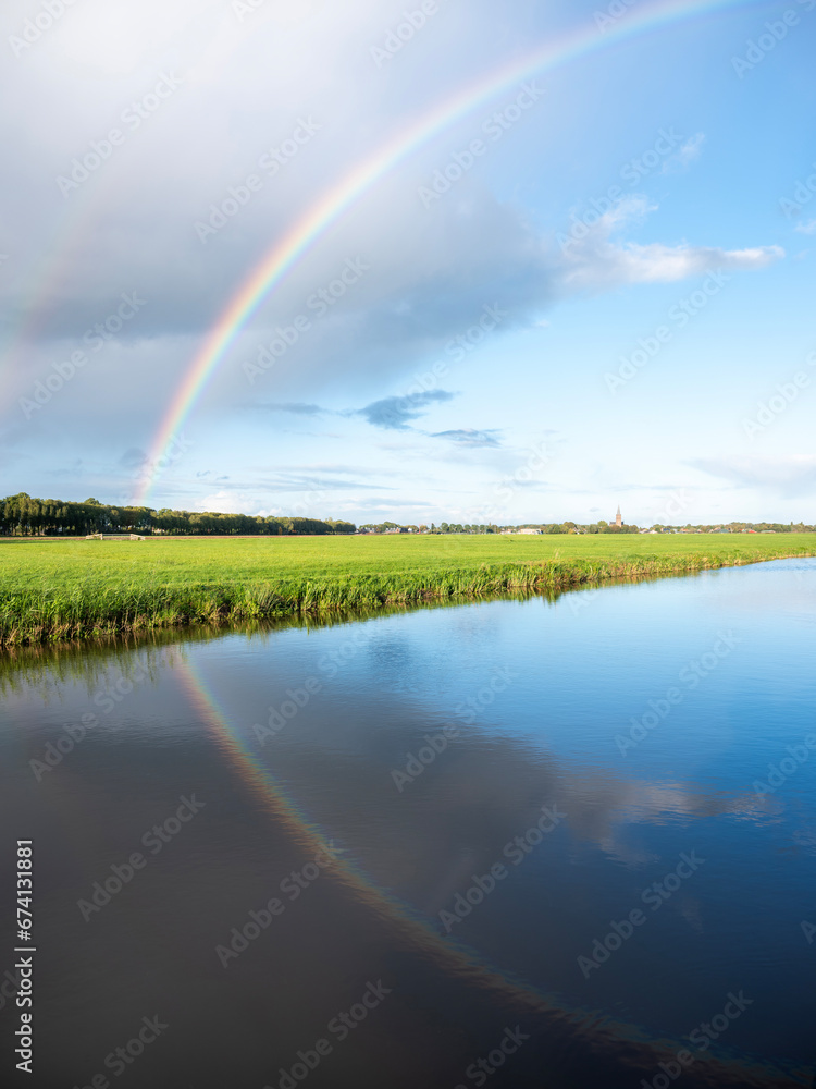 canal between dutch meadows in holland near utrecht with rainbow in blue sky canal between dutch meadows in holland near utrecht with rainbow in blue sky