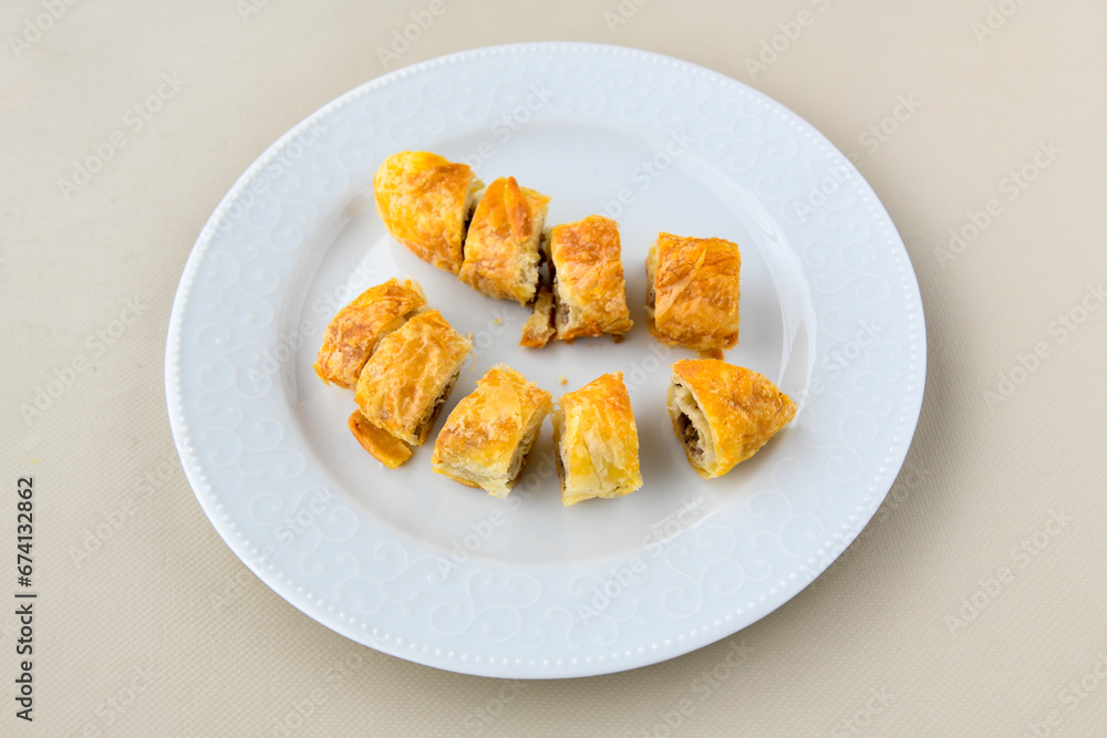 Turkish style meat stuffed filo dough borek served kol boregi. Cheese and minced pie are sliced on a marble background. Turkish name: Kol Boregi, ispanakli, kiymali, Su Boregi Turkish style meat stuffed filo dough borek served kol boregi. Cheese and minced pie are sliced on a marble background. Turkish name: Kol Boregi, ispanakli, kiymali, Su Boregi