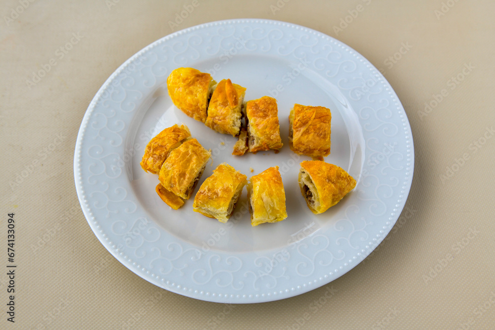 Turkish style meat stuffed filo dough borek served kol boregi. Cheese and minced pie are sliced on a marble background. Turkish name: Kol Boregi, ispanakli, kiymali, Su Boregi Turkish style meat stuffed filo dough borek served kol boregi. Cheese and minced pie are sliced on a marble background. Turkish name: Kol Boregi, ispanakli, kiymali, Su Boregi