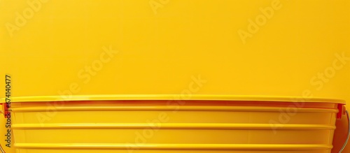 A picture was taken of a plain plastic bucket capturing the abstract essence of a yellow background seen through a skylight