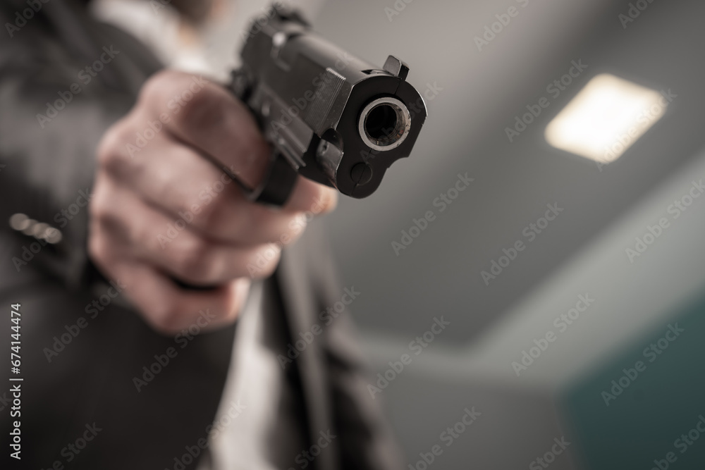 A man in a suit pointed a gun A man in a suit pointed a gun