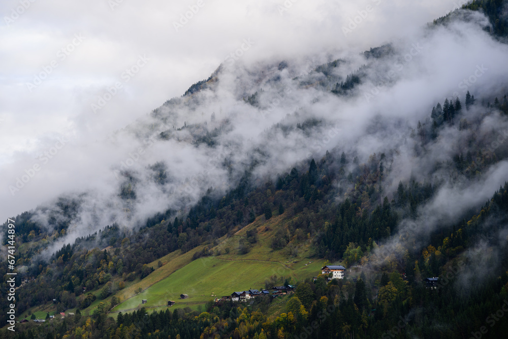 mountain landscape in the austrian alps 
with clouds and fog