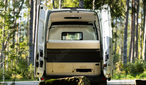 Camper van conversion back doors open with wood interior in Norway forest photo