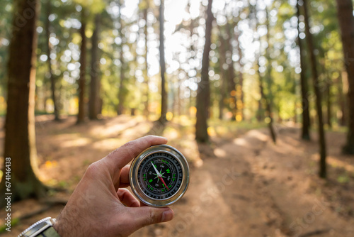 Holding a compass against the background of the forest