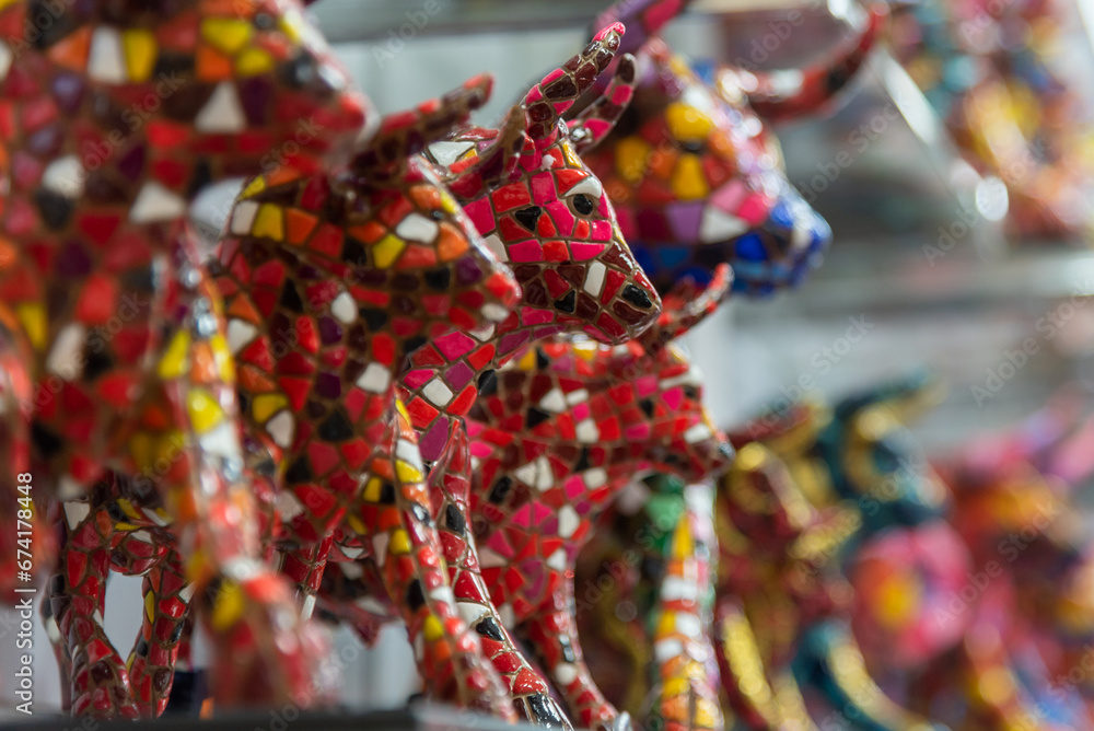 Valencia, Market, Spain, 2022, Multicolored mosaic figurine of bull in Gaudi style. Spanish traditional gifts in the souvenir shop.