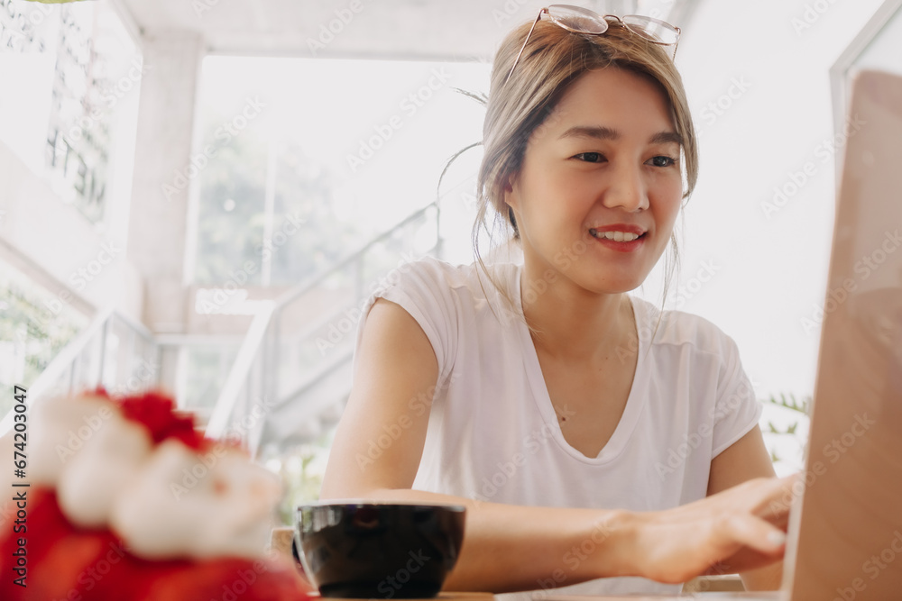 Happy freelance asian woman working with laptop in the cafe. Happy freelance asian woman working with laptop in the cafe.