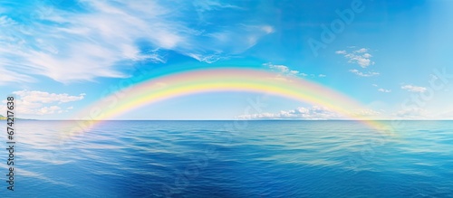 The tranquil sea reflecting the vibrant colors of the arched spectrum © 2rogan