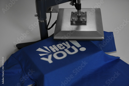 Printing logo. Heat press with t-shirt on white table, closeup