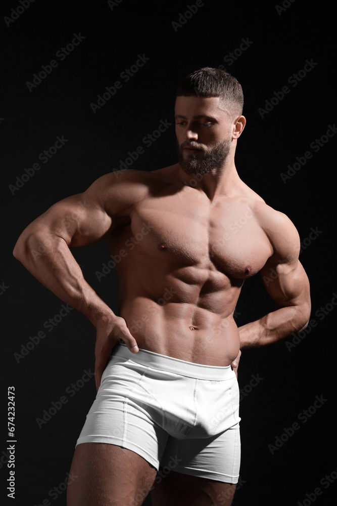 Fototapeta premium Young man in stylish white underwear on black background