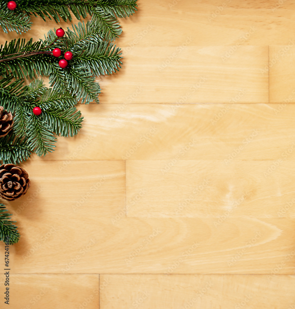 Fototapeta premium Christmas background of green fir branches with red berries and brown cones.
