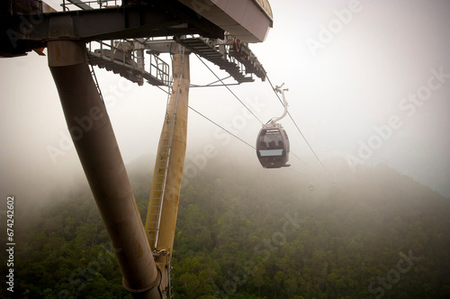 Amazing cable car lines and carriages over jungle in thick fog at the Langkawi Skybridge cable car in Malaysia photo
