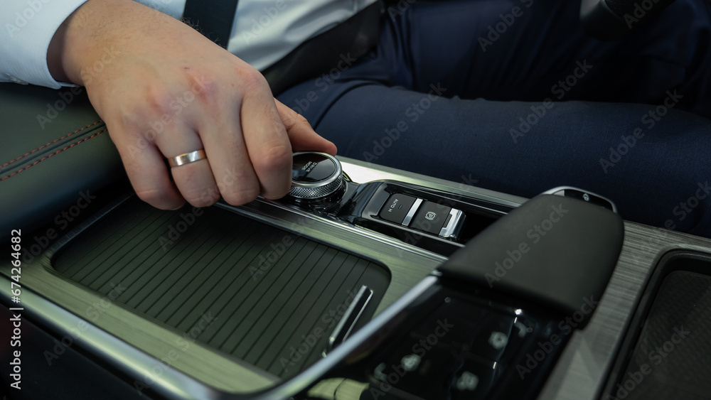 Close-up of a man's hands on the automatic transmission of a modern car. Close-up of a man's hands on the automatic transmission of a modern car.