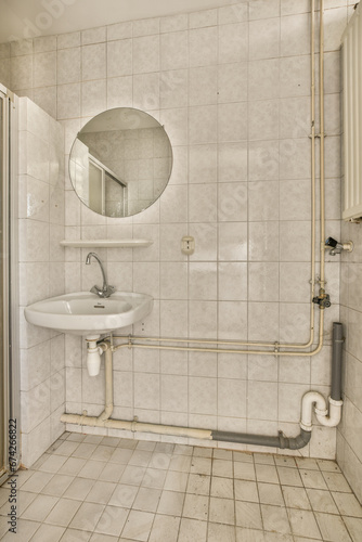 a bathroom with a sink, mirror and toilet roll on the wall next to it is a white tiled floor