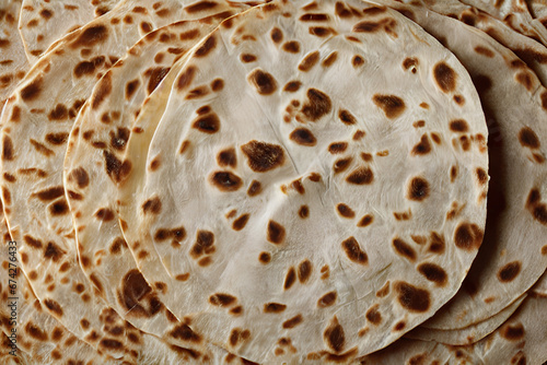  captivating photograph of a thin, pliable tortilla, highlighting its flexibility and a warm, golden-brown hue that conveys the essence of freshly made, handcrafted tortillas. 