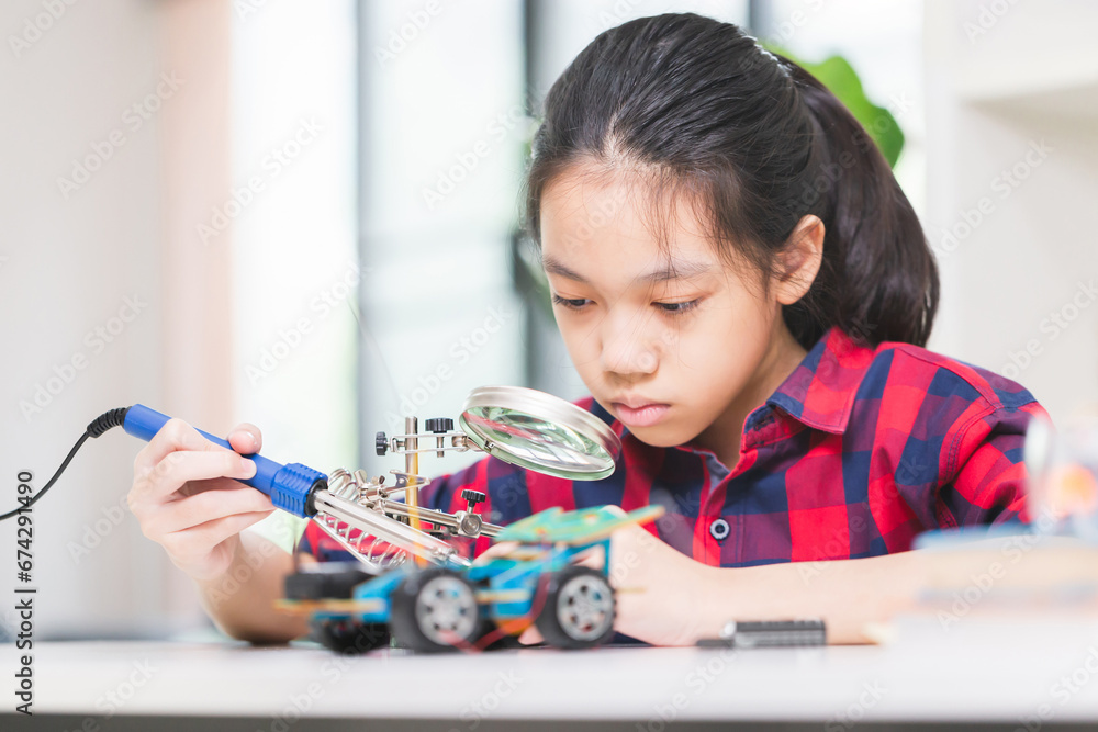 Child girl student build robotic cars, kid learning programming robot vehicles Child girl student build robotic cars, kid learning programming robot vehicles