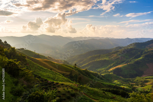 Natural view point of green mountain with beautiful golden evening light and cloud sky in Doi Chang Mountains of Chiang Rai Province, Northern of Thailand © isarescheewin