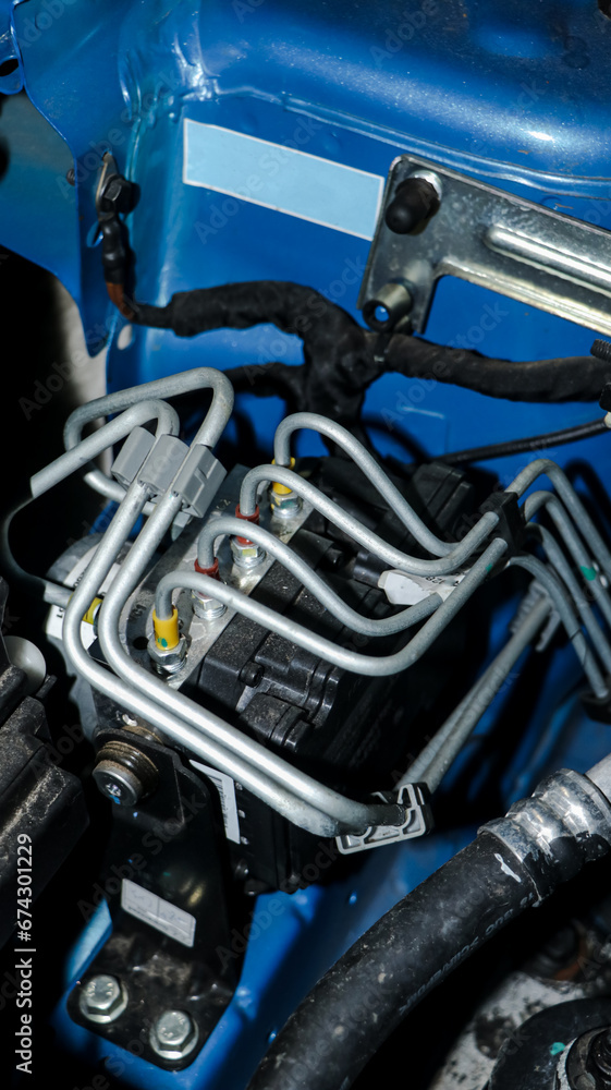 Fototapeta premium an electronic control unit(ECU) with wired connections controlling various operations of a vehicle located near the engine on the hood 