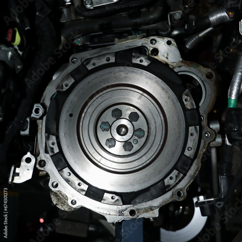 metallic flywheel mount on the transmission assembly of a vehicle in a auto repair shop in closeup photo
