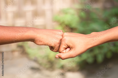 Two human hands joined together in fists and blur background © Rokonuzzamnan