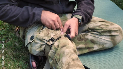 The tactical medic applies the tourniquet to his leg. A military instructor demonstrates applying a tourniquet to stop bleeding on a leg. Military Medicine photo