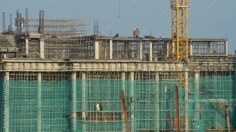 Panoramic view of the construction process of a new building with the participation of many workers Panoramic view of the construction process of a new building with the participation of many workers