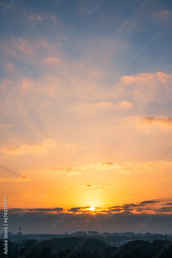 日の出の太陽と朝焼けの高積雲（縦構図）