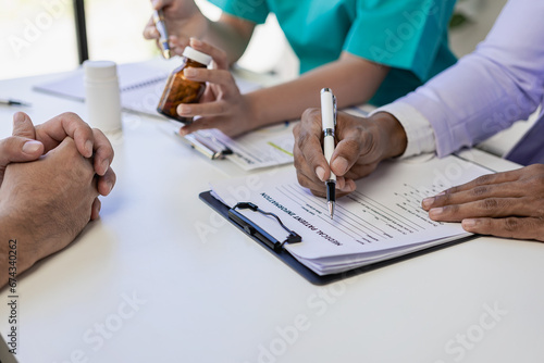 Friendly or Asian doctor who helps discuss male medical test results and young male patient while consulting and
Explain. Doctor and patient sit together at a table in the clinic. photo
