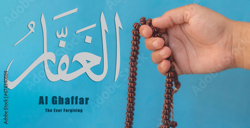 Hand of Muslim woman holding prayer beads, 99 Names of God, Muslim woman praying Name Of Allah Al Ghaffar photo